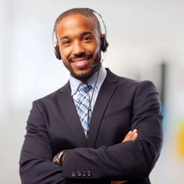 A smiling black man wearing a headset.