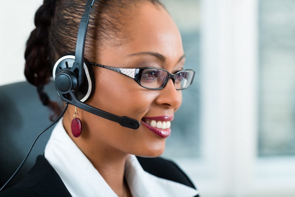 A woman wearing a headset in an office providing Virtual Assistant service